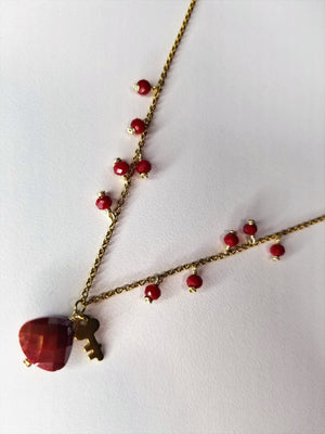 Gold metal necklace with red beads and key