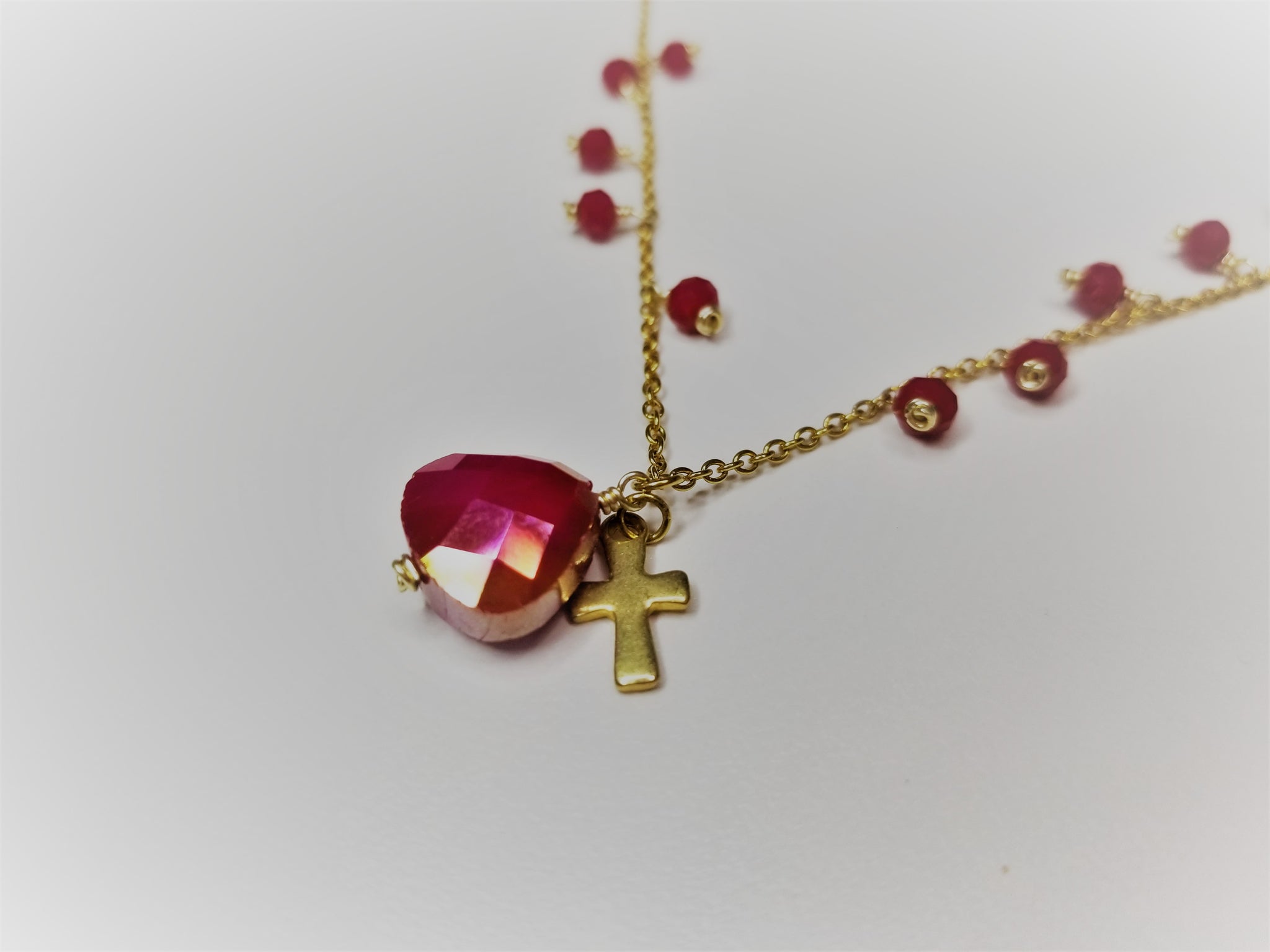 Gold metal necklace with red beads and cross